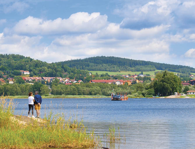 Romantic view of Lipno and tourists waiting on the shore for arriving ferry in Bli   Lhota. Lipno lake.